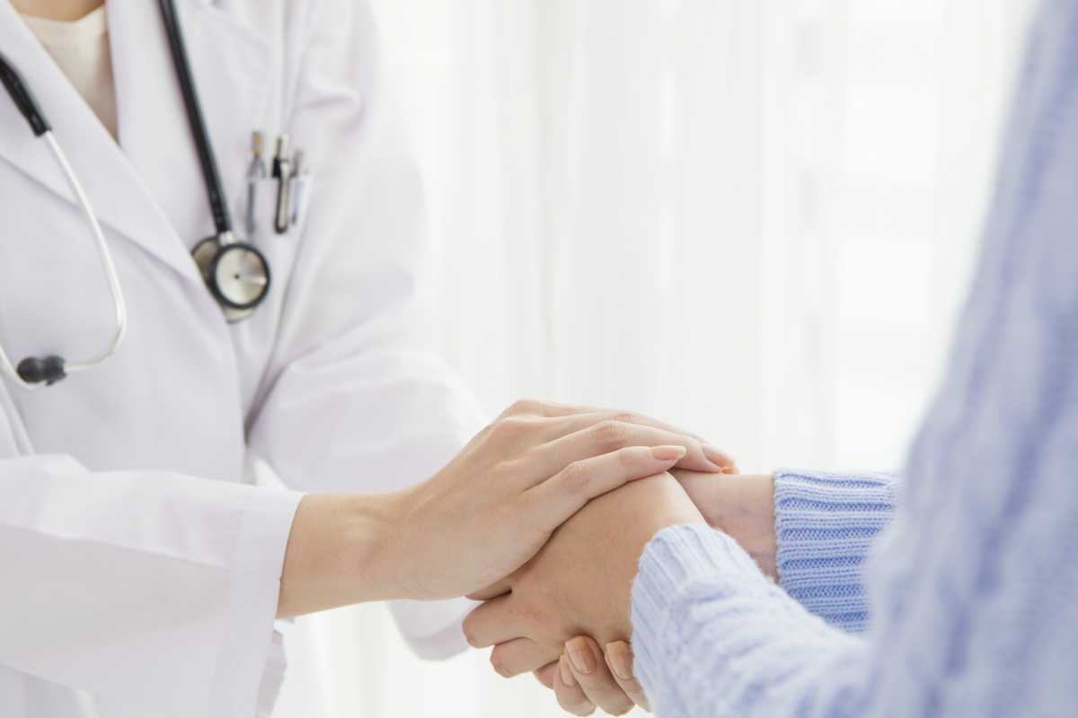 physician holding a patient's hands