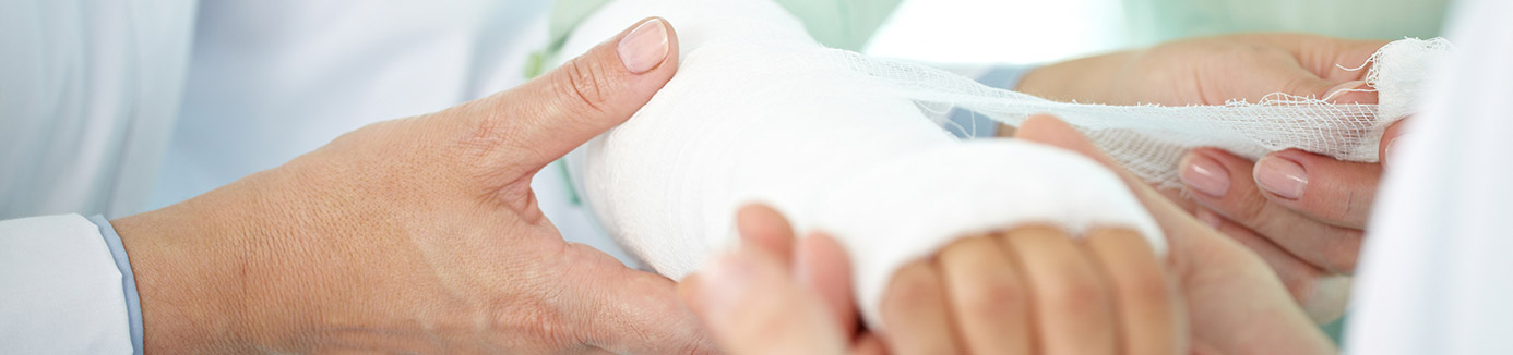 A patient's hand is wrapped by a health care provider