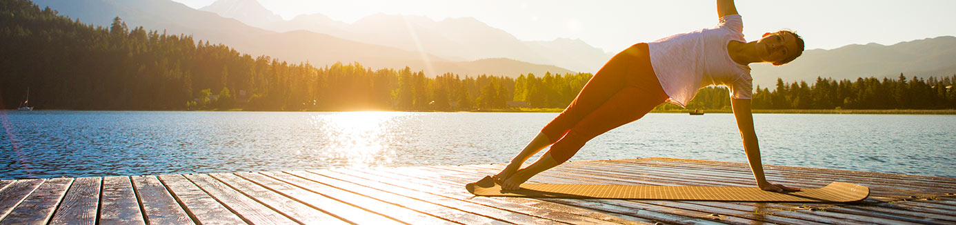 Woman doing a side plank on a dock at Donner Lake