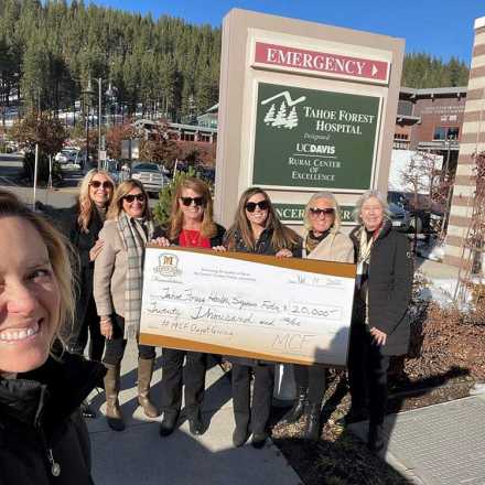 Seven women outside Tahoe Forest Hospital holding a giant check from Martis Camp 