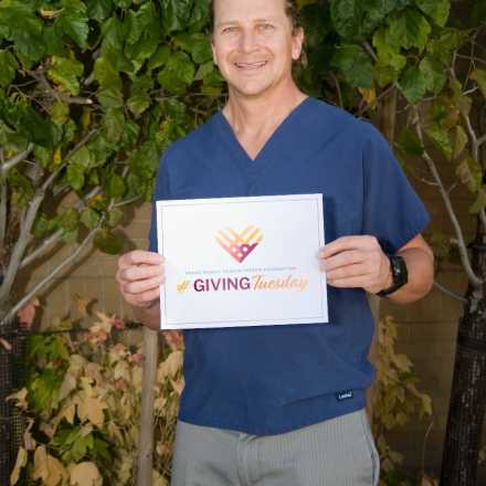 Dr. Rosengreen holding a giving tuesday certificate