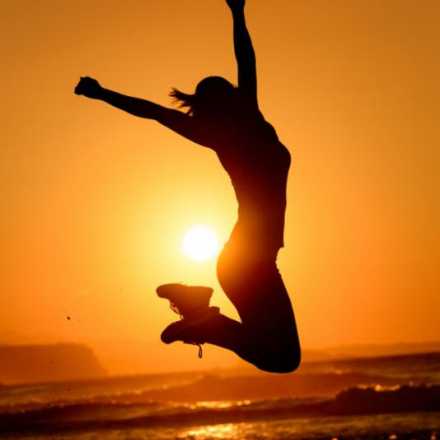 Woman jumping in the sunset at the beach