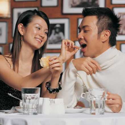 Woman feeding man and smiling