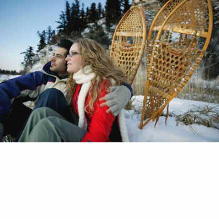 couple in the snow with snowshoes behind them
