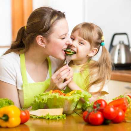 mother and daughter eating vegetables