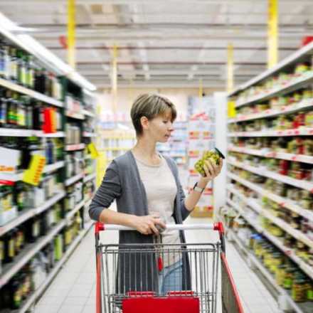 Woman looking at a food label at the grocery store