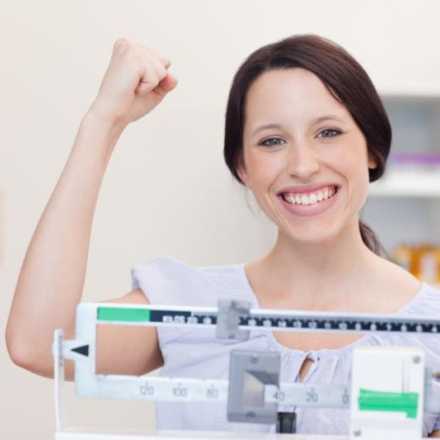 Happy woman weighing herself