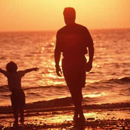Father and child walking on the beach