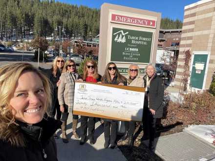 Seven women outside Tahoe Forest Hospital holding a giant check from Martis Camp 