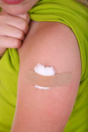 Cotton swab and band-aid covering a flu shot