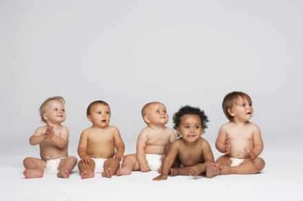 Five babies sitting in diapers