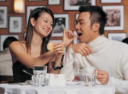 Woman feeding man and smiling