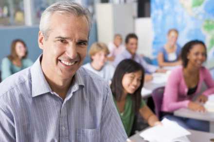 Man smiling in front of a classroom