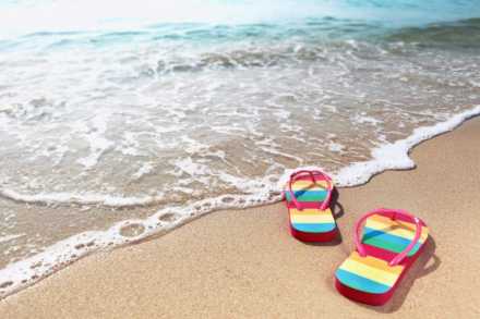 rainbow flip flps on a beach