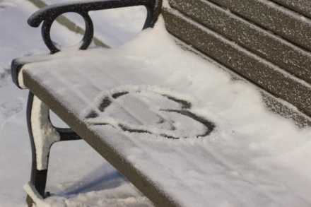 Heart drawn in snow on a bench