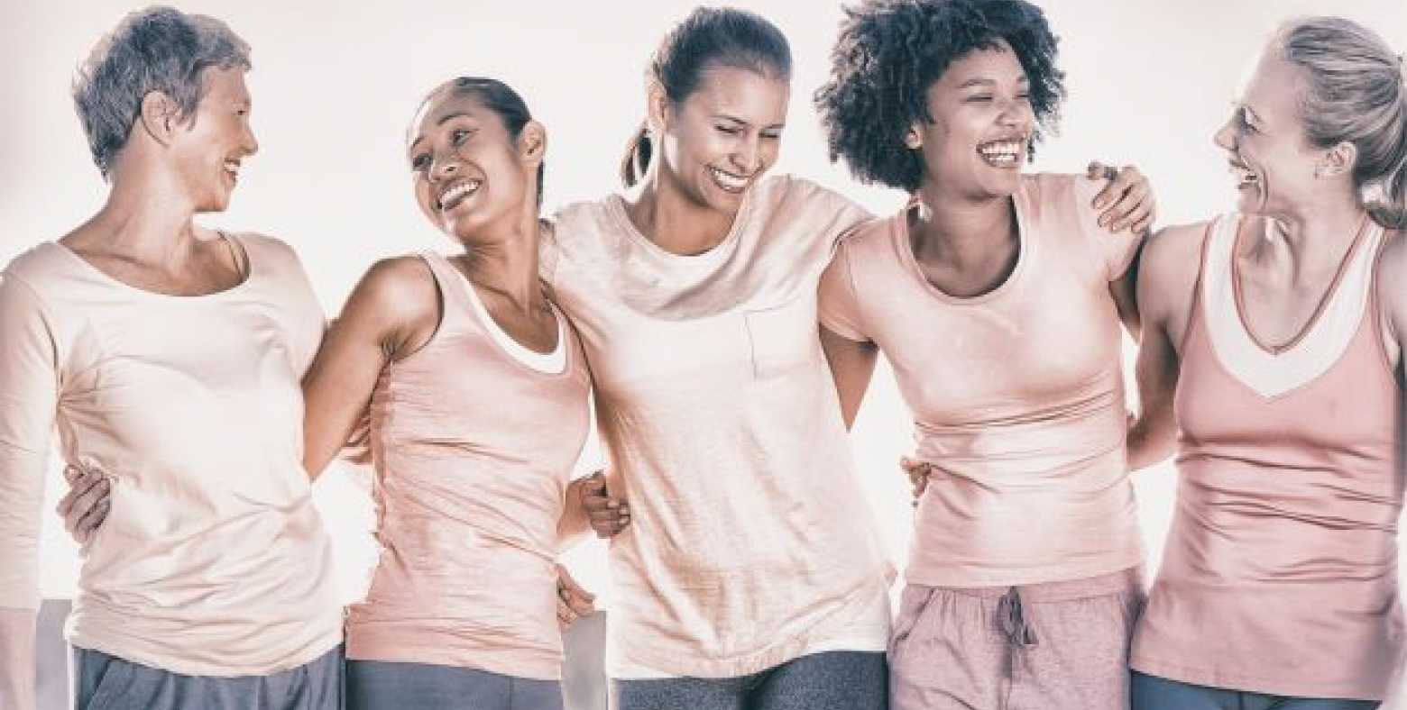 5 women in pink together smiling 