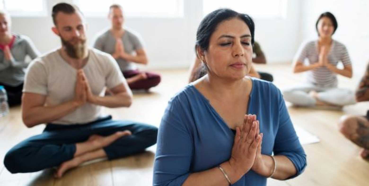 yoga class sitting in prayer hand pose