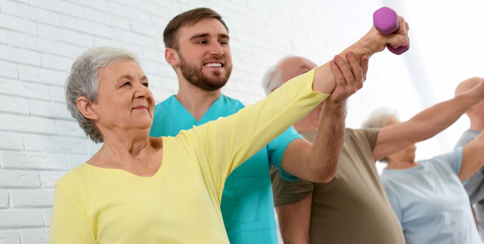 exercise specialist working with elderly with dumbbell
