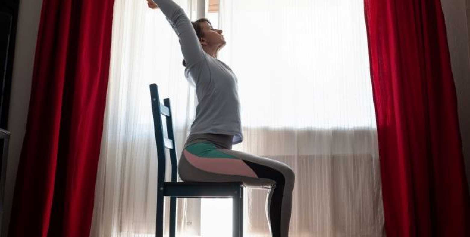 woman doing yoga pose while sittng on chair