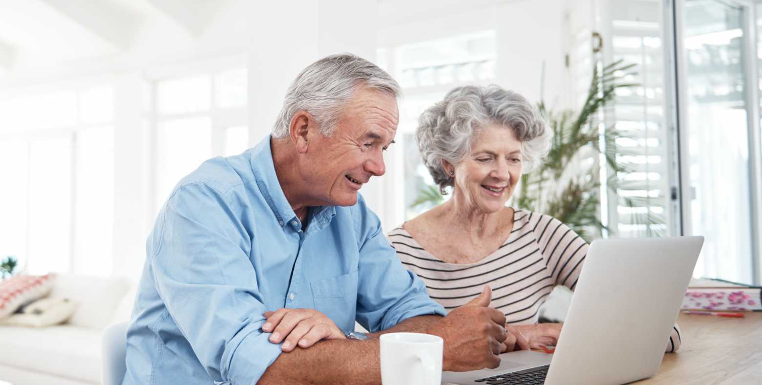 elderly couple looking at laptop