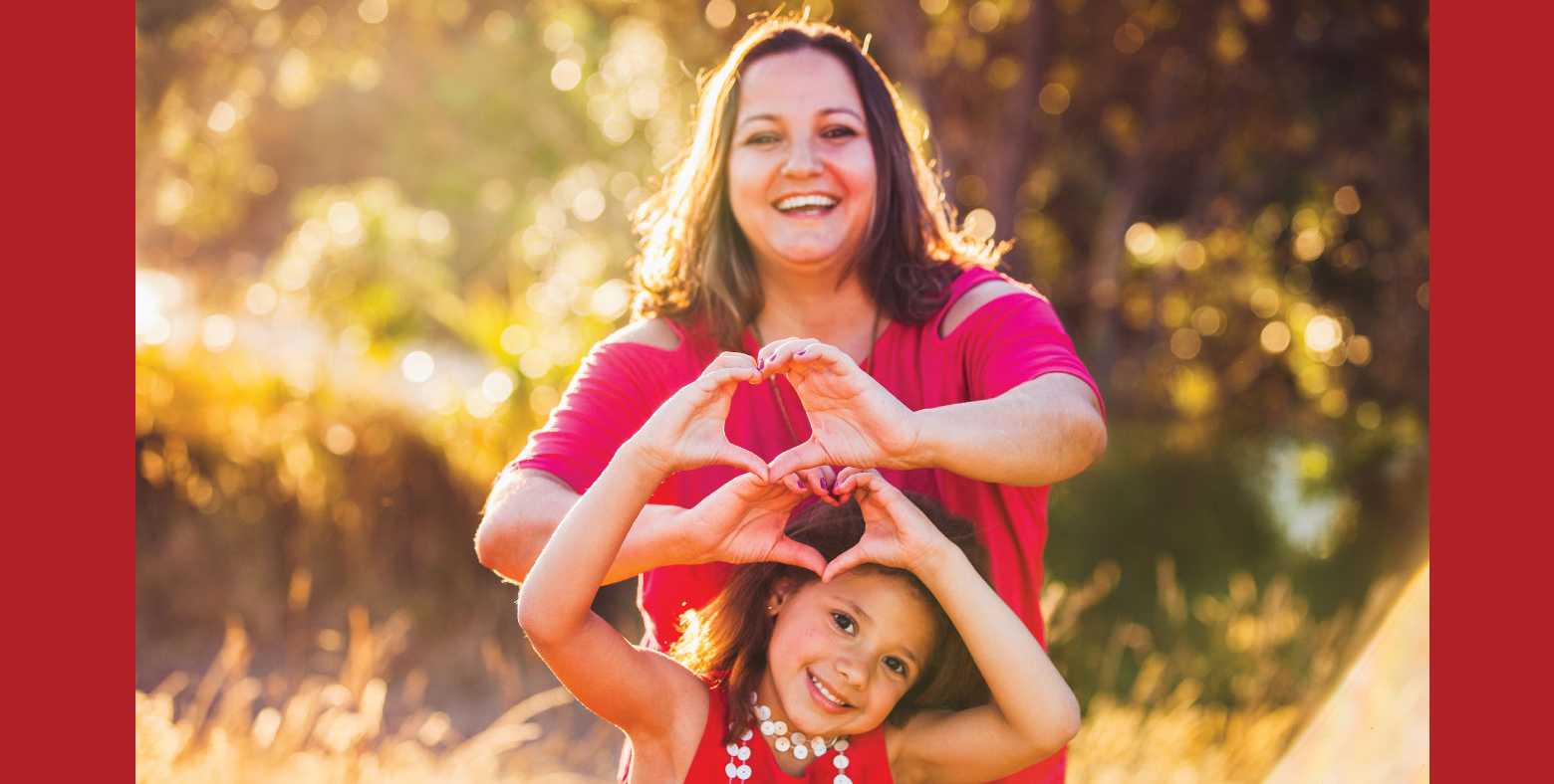 mother and daughter forming heart with hands
