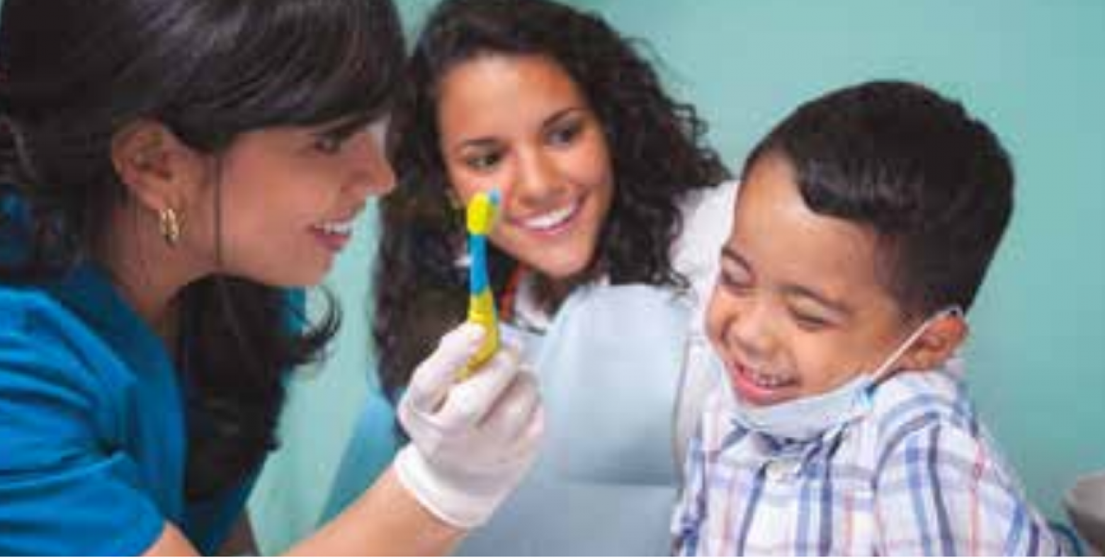 Dentist helping child with toothbrush