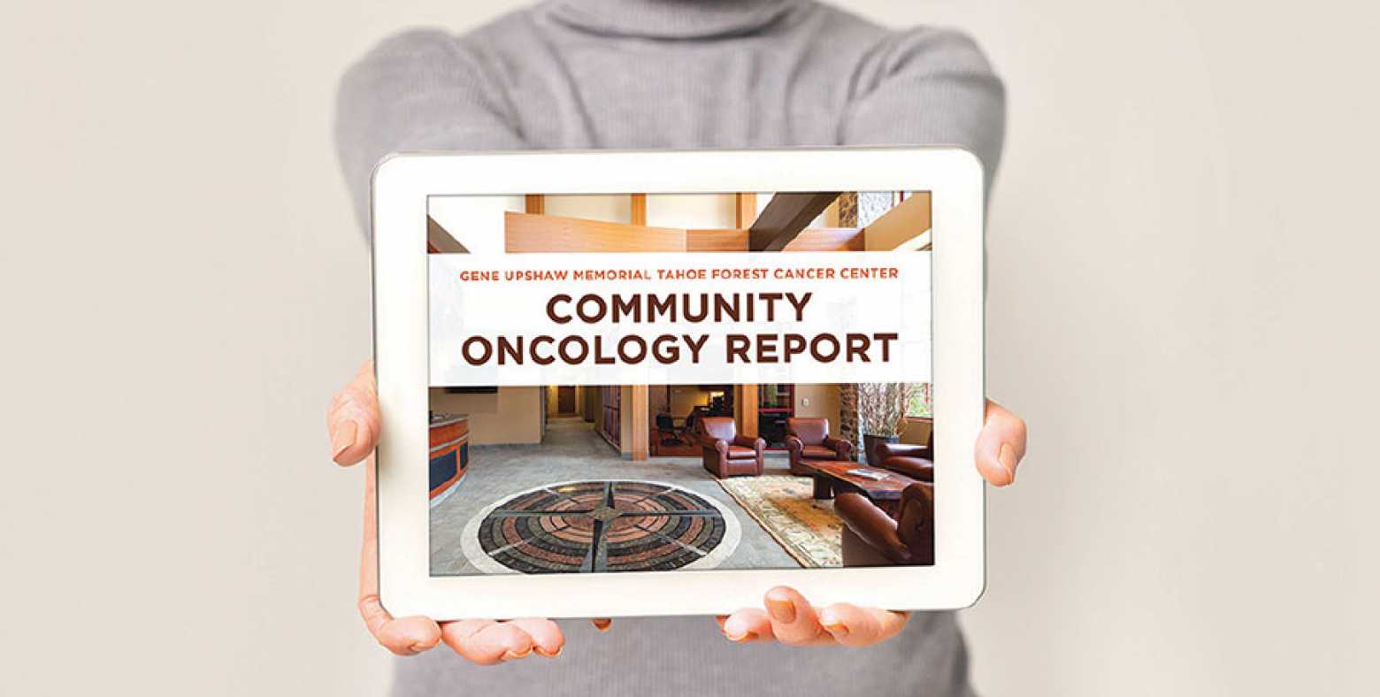 Woman holding an iPad with Community Oncology Report on the screen