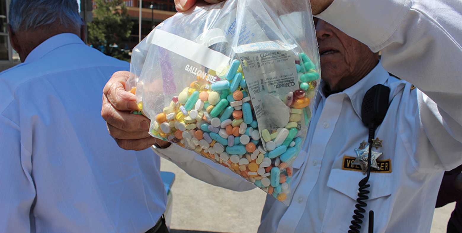 Police officer holding up a bag of opioid pills