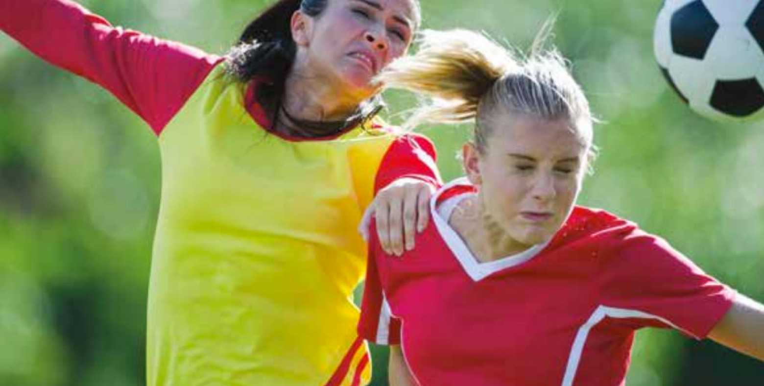 Two women going for a header in a soccer game