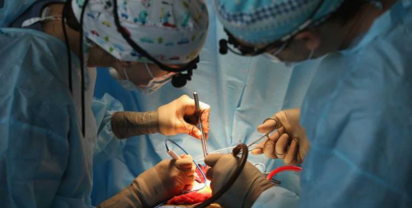 Two doctors performing surgery on a patient