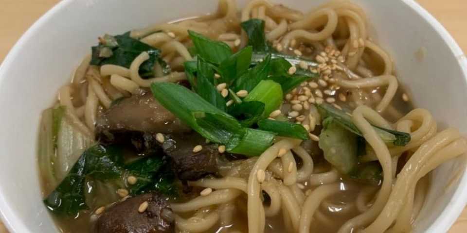 Bowl of ginger garlic noodle soup with bok choy