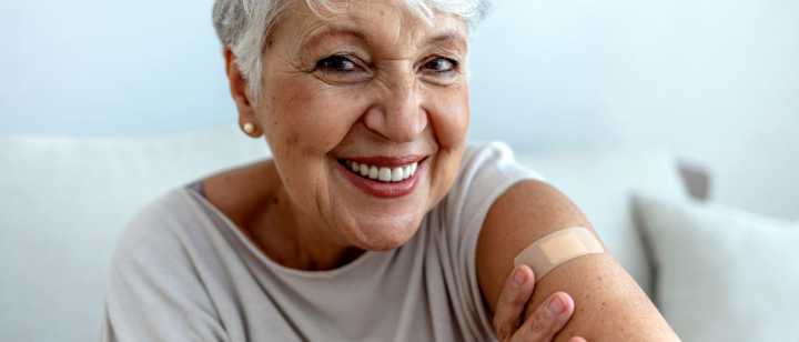 elderly woman showing arm with bandage