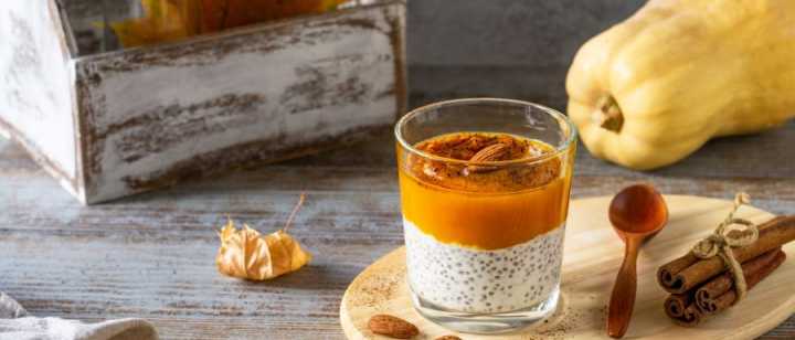 pumpkin chia pudding in a cup with fall decor around  it