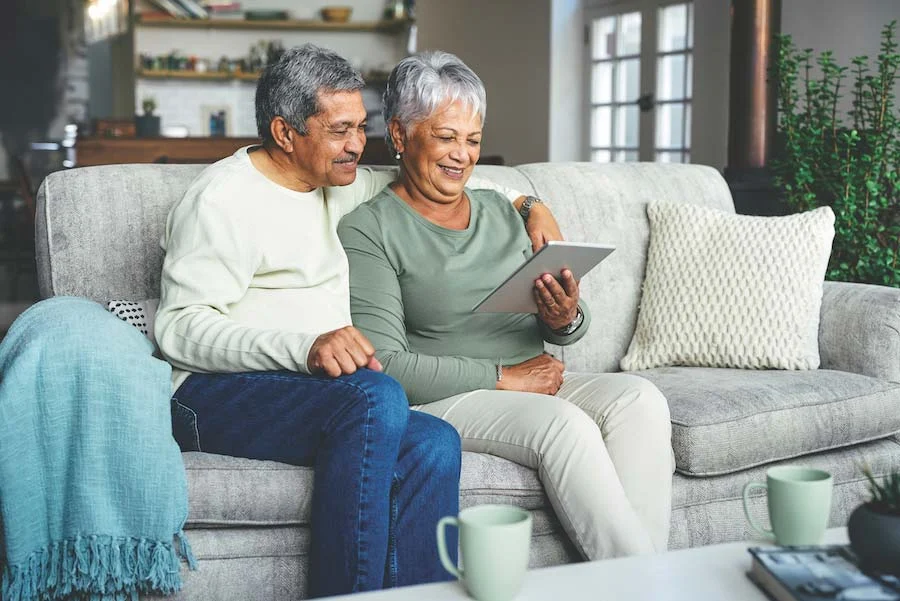 SeniorCouple_OpenEnrollment-1357783004-web-news-item Senior couple looking at a screen on a couch