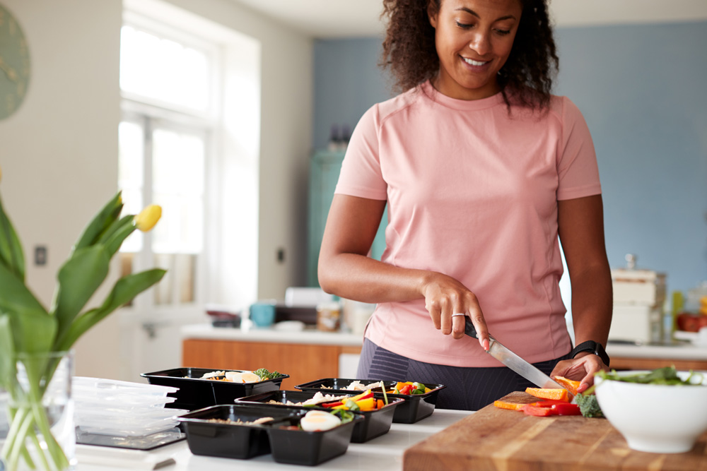 female meal prepping in kitchen