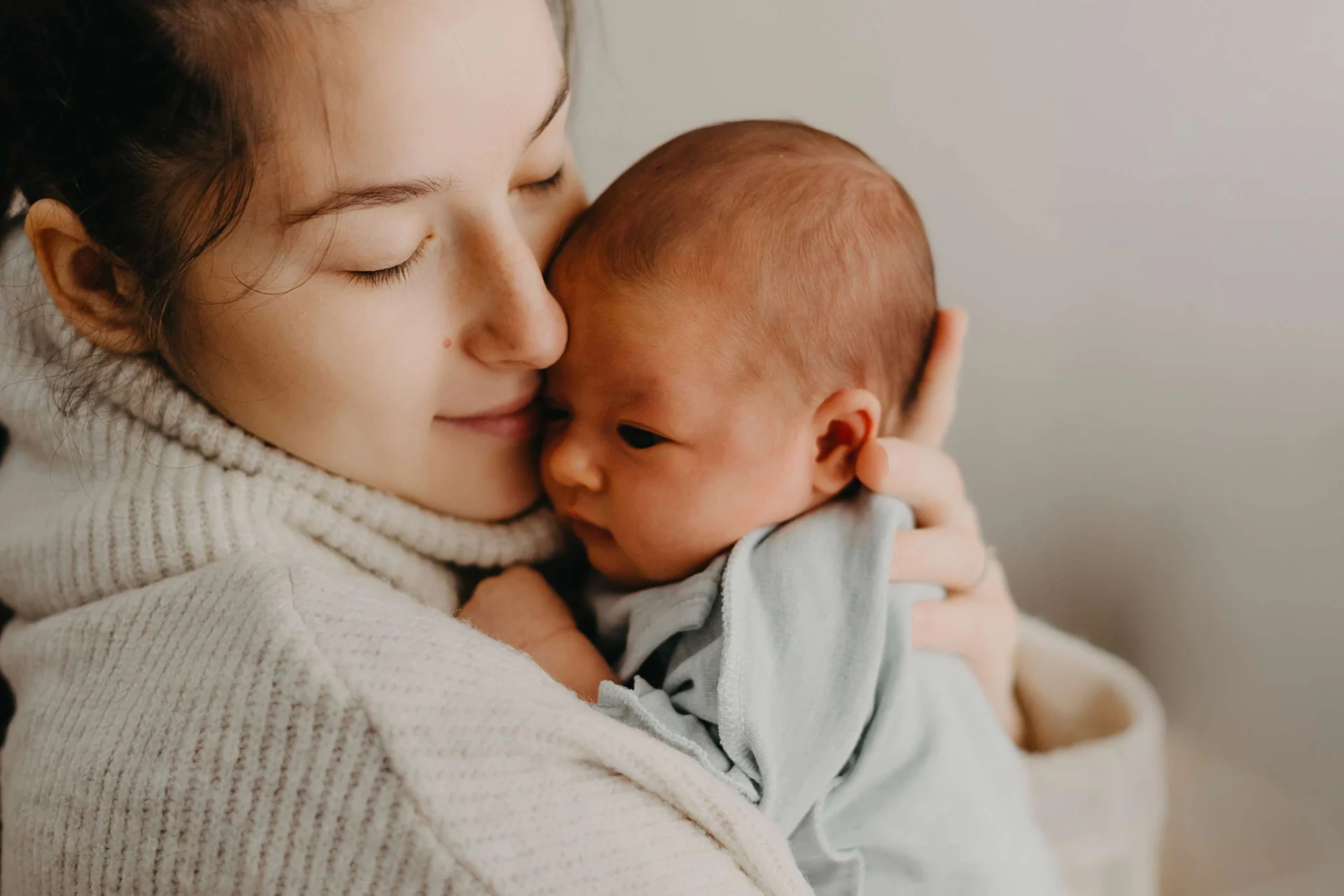 Mom cuddling sweet newborn baby