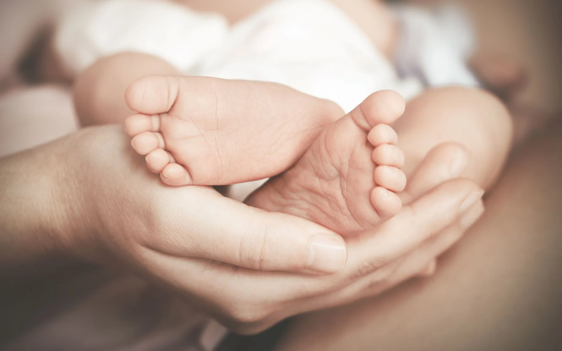 Baby-Feet.AdobeStock_211505401.small__0 mom holding baby's feet