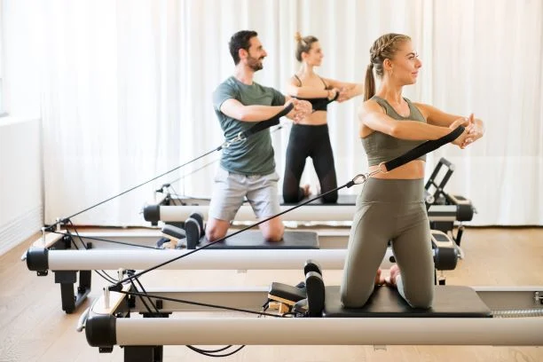 Pilates-Fundamentals-Workshop.small_ Group of people exercising on pilates reformer