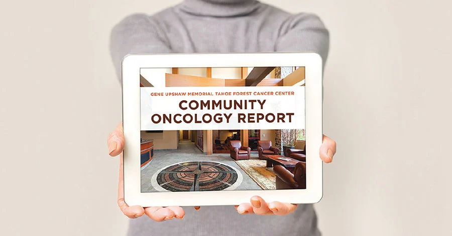 Woman holding an iPad with Community Oncology Report on the screen