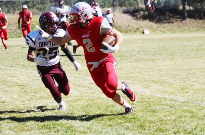 so_a_football_runningback_web_2 Young football player with ball blocks oncoming defender