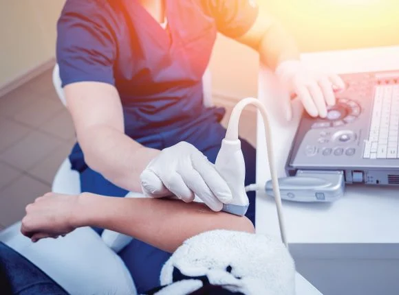 ultrasound tech performing ultrasound on patient's arm