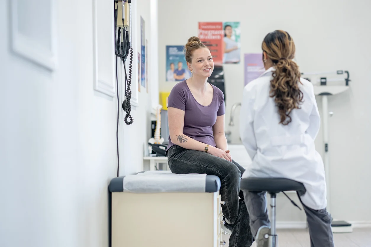 doctor talks to patient in exam room