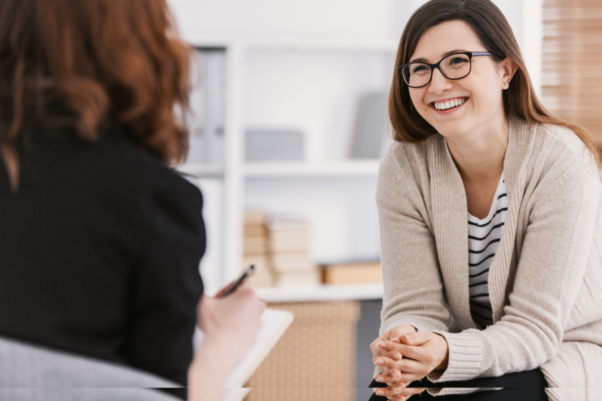 smiling female sitting in front of health practitioner