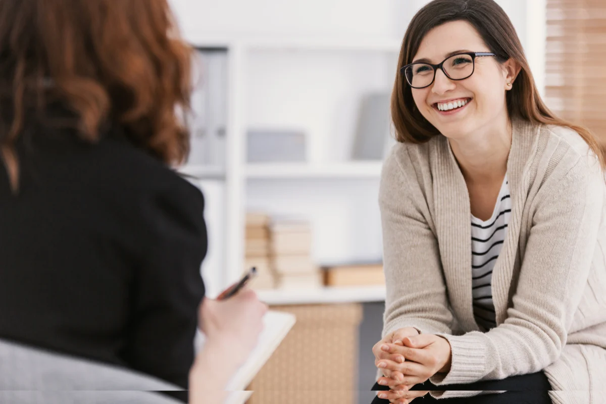 smiling female sitting in front of health practitioner