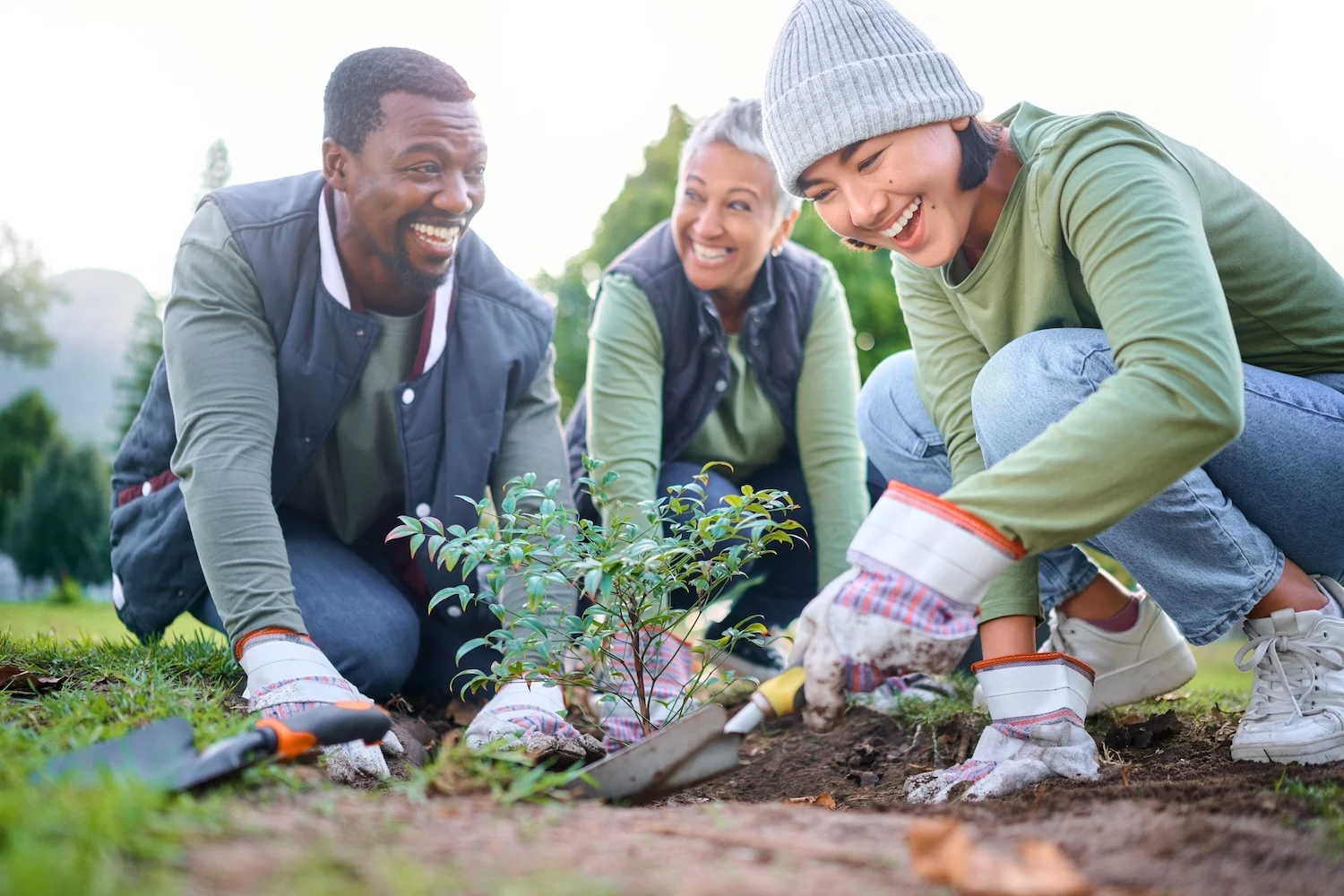 male and 2 females planting tree