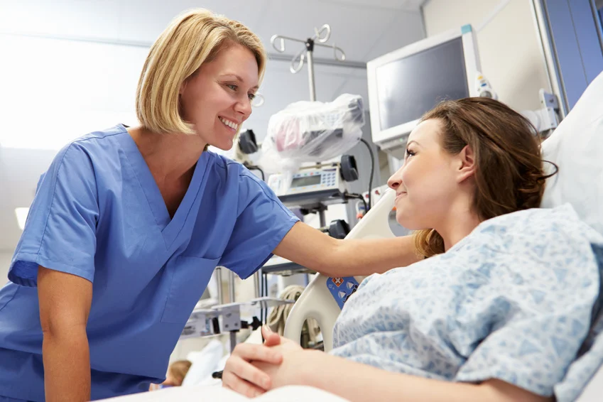 Young Female Patient Talking To Nurse In Emergency Room doctor smiles on patient