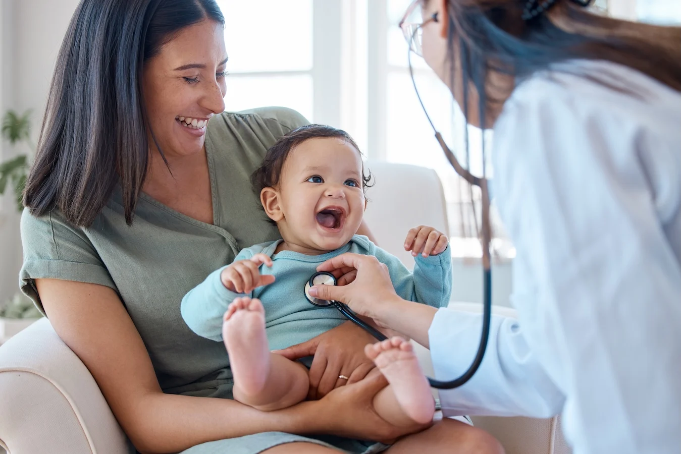 Mother, baby and stethoscope of pediatrician for healthcare consulting, check lungs and breathing for heartbeat. Doctor, happy infant kid and chest assessment in clinic, hospital and medical analysis smiling mom and baby with doctor holding stethoscope to baby's chest