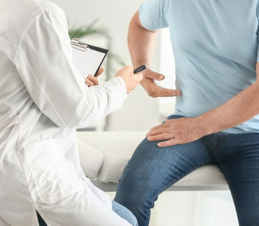 patient pointing to side of abdomen in front of doctor