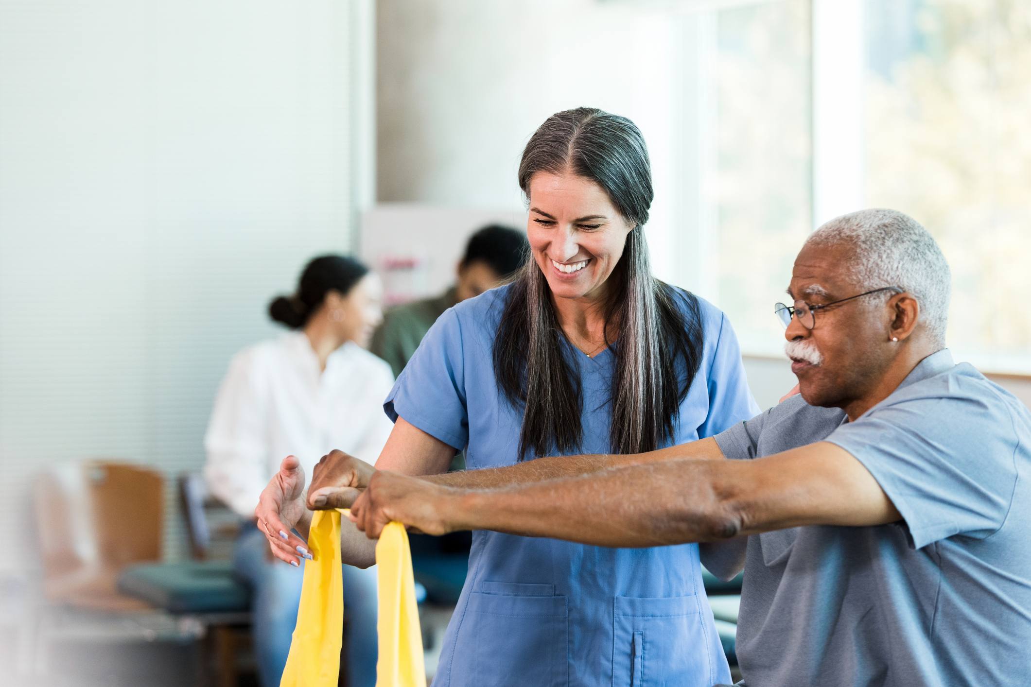 occupationaltherapy doctor helps patient practice with resistance band