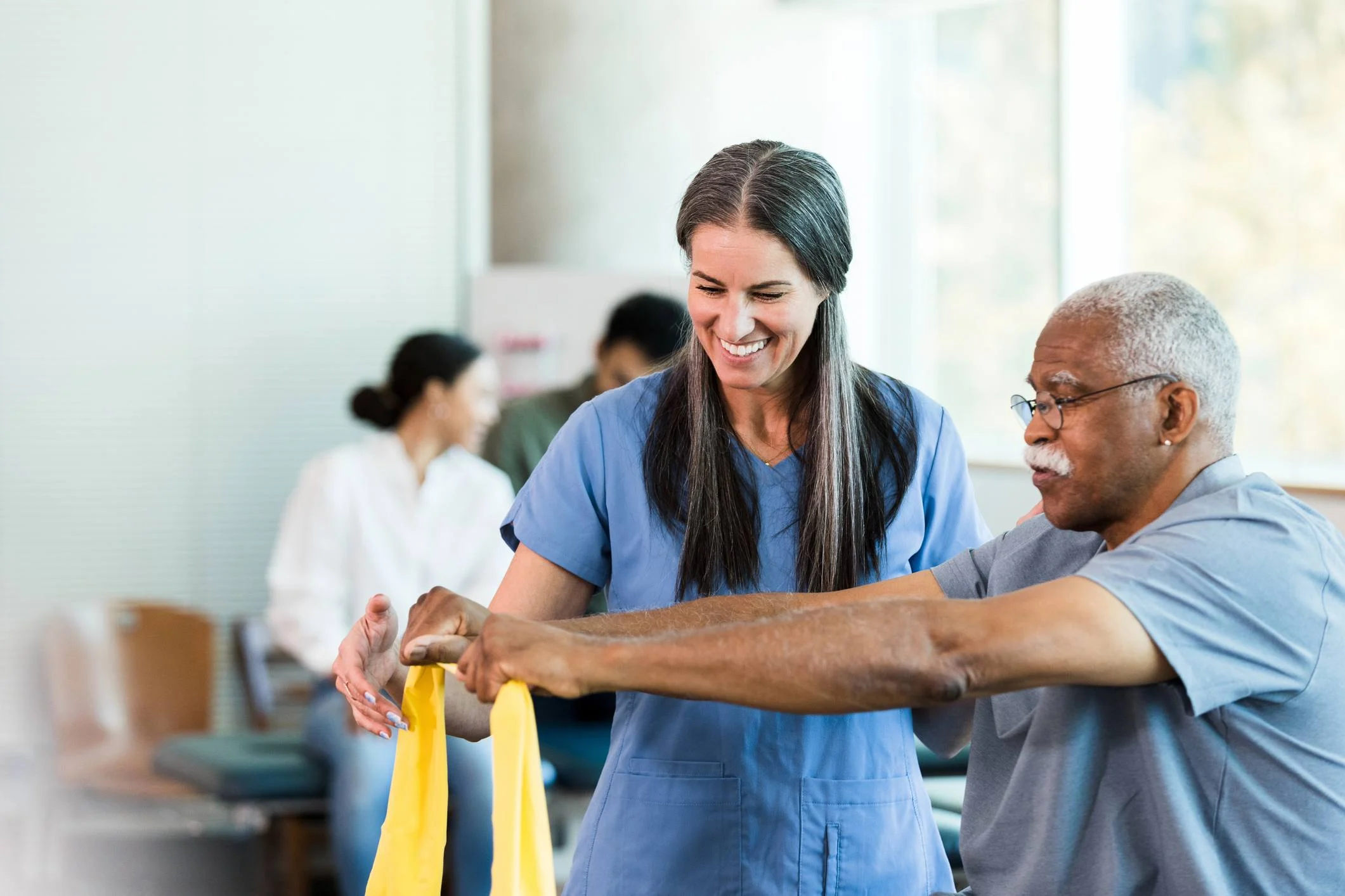 doctor helps patient practice with resistance band